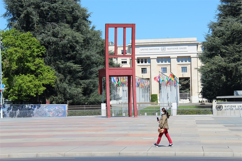 ?να? πεζ?? περν?ει δ?πλα απ? το Παλ?τι των Εθν?ν (Palais des Nations) στη Γενε?η, τη? Ελβετ?α?, στι? 14 Απριλ?ου του 2020. (Xinhua/Nie Xiaoyang)